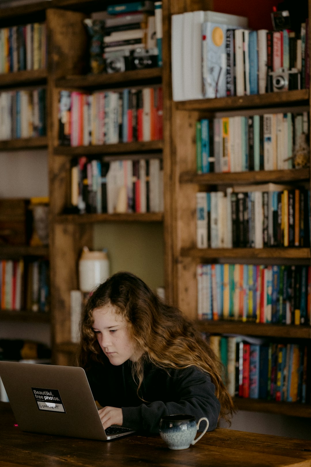 Young teen doing schoolwork at home after UK schools close due to the Coronavirus.